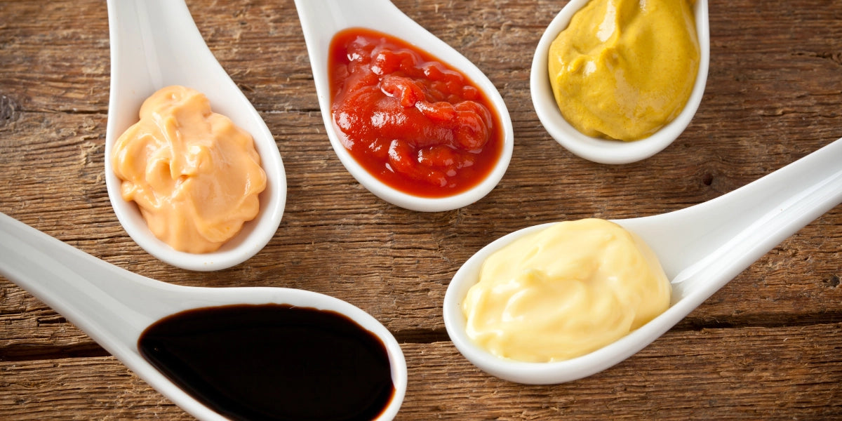 Löffel mit verschiedenen Soßen auf einem Tisch